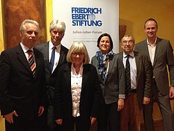 Sechs Personen stehen vor dem Roll-Up der Friedrich Ebert Stiftung und lächeln